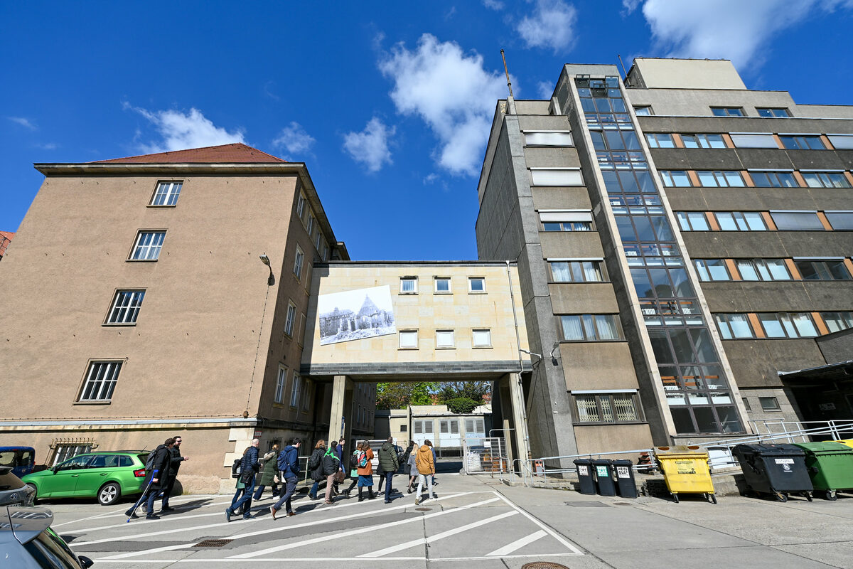 Group of people running towards old building