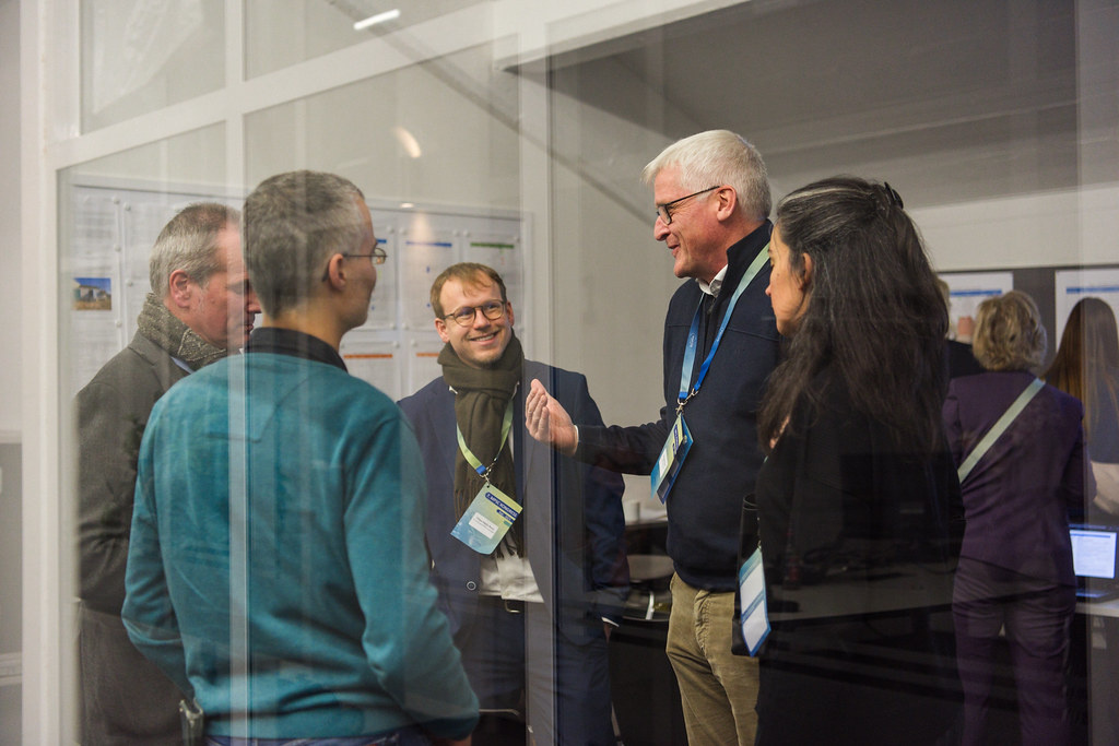 Men are standing in a circle and talking.