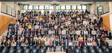 Gruppenfoto von vielen Menschen auf einer Treppe sitzend