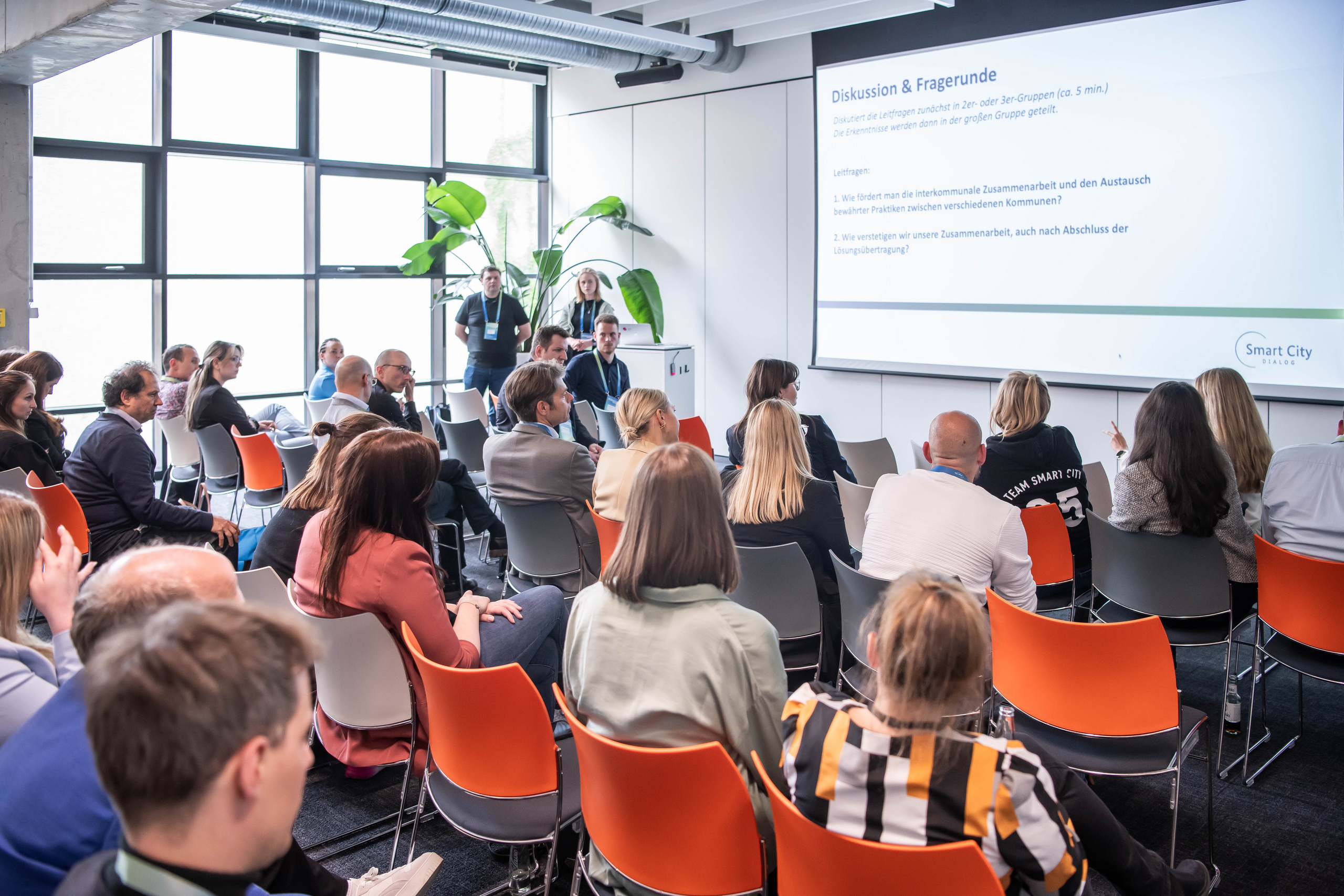 Gruppe von Menschauen sitzt im Publikum und schaut auf eine Präsentation