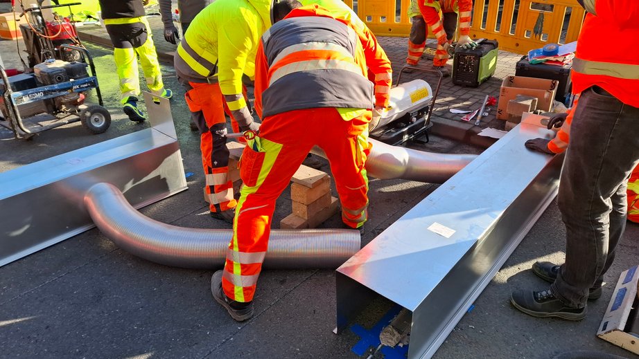 Bauarbeiter beheizen Straßenbelag zum Aushärten