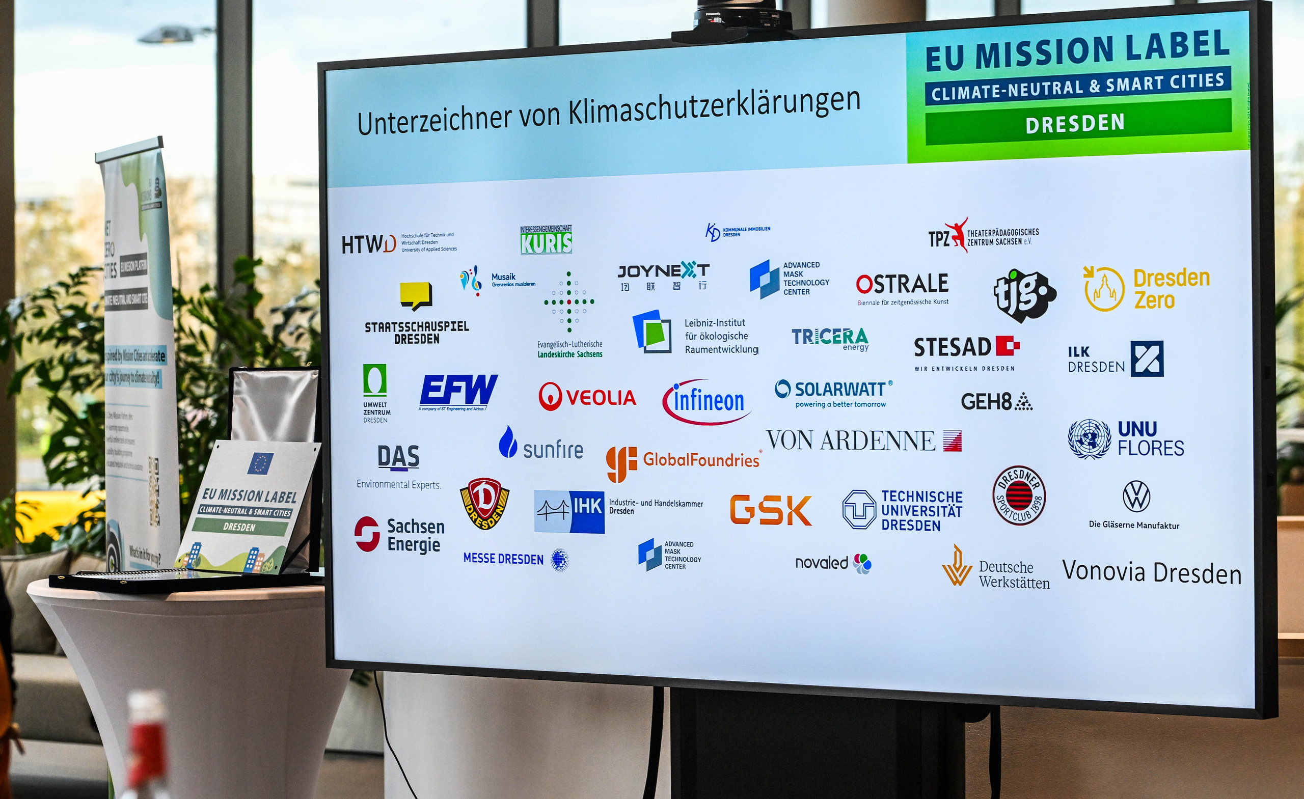 Großer Monitor mit Logosammlung aller Partner