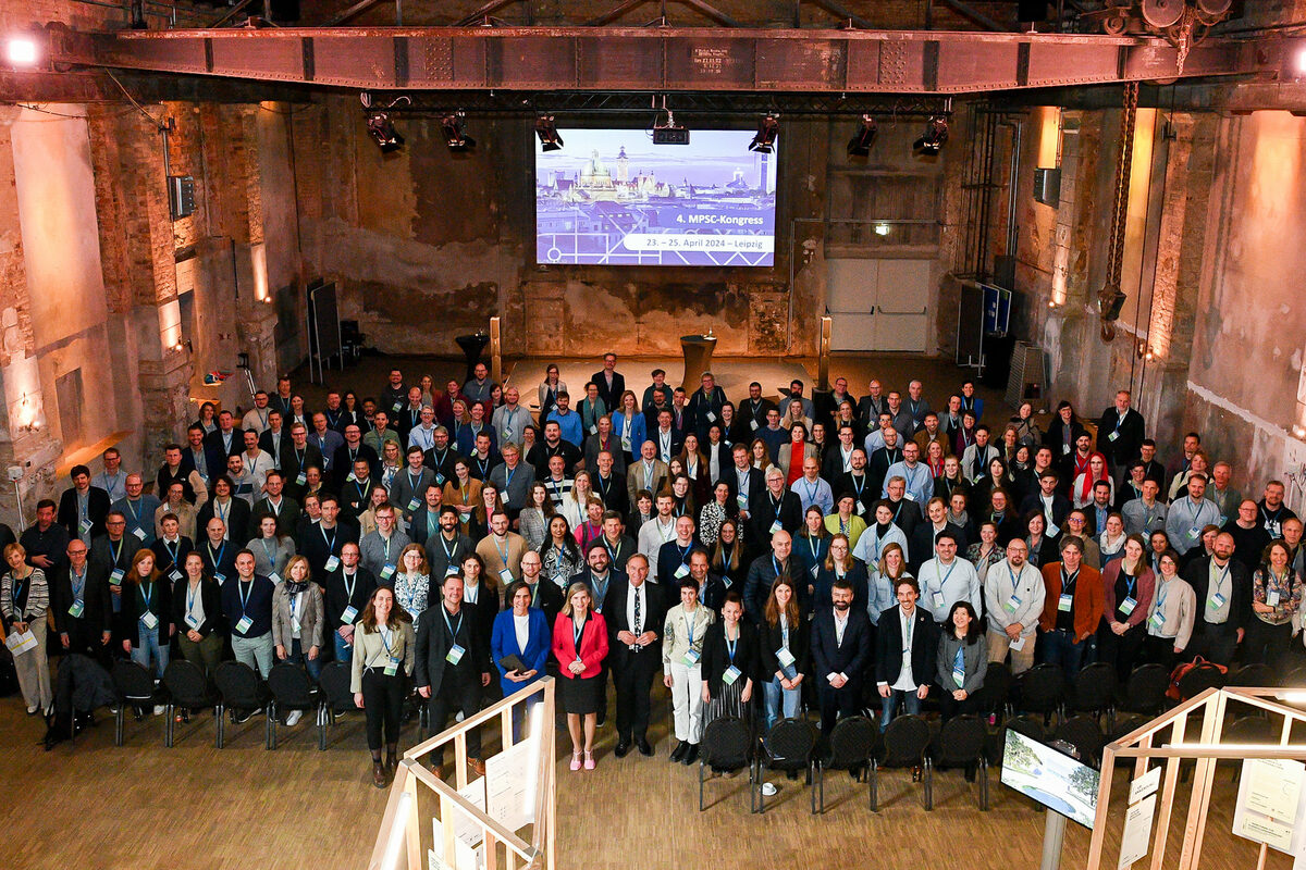 Group photo of many people in an industrial hall