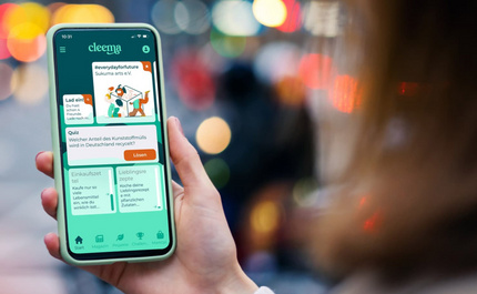 Cleema App wird auf einem Smartphone einer Frau angezeigt