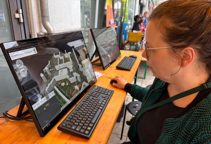 Besucherin sitzt vor dem Bildschirm und probiert das Co-Design-Tool U_CODE